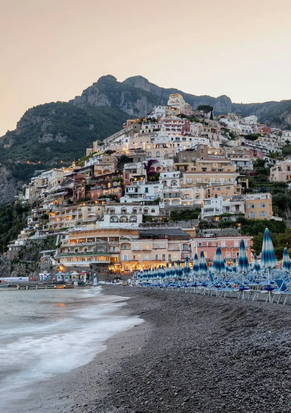 Blick von oben auf die Spiaggia Grande von Positano, mit bunten Häusern, die zum Meer hinabführen, und an Land gezogenen Booten