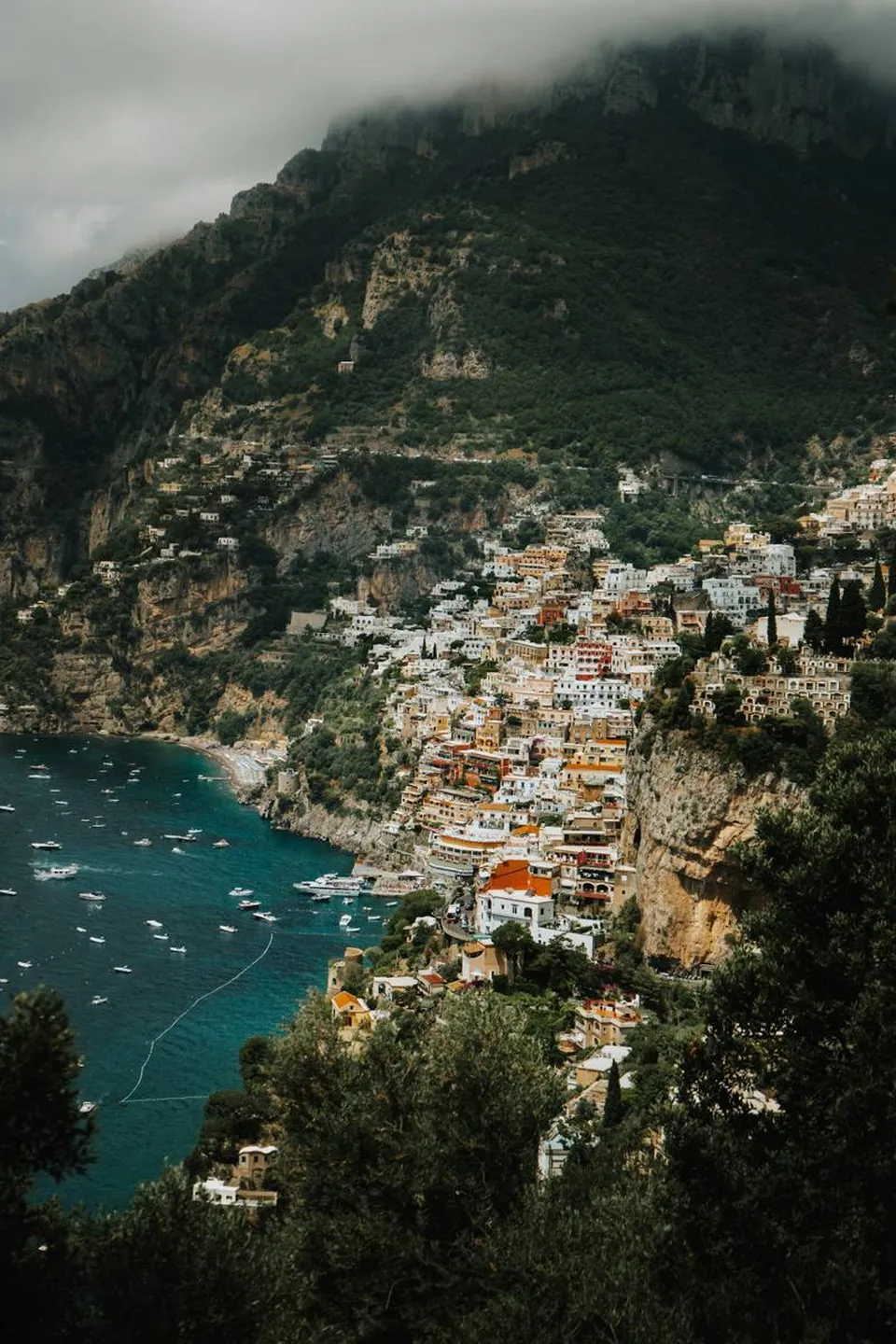 Positano von oben: pastellfarbene Häuser, die sich wie eine Kaskade zum Meer hinabziehen, und die Majolikakuppel von Santa Maria Assunta
