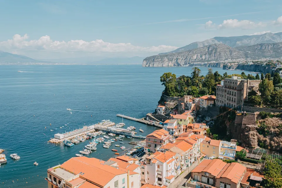 Familie spaziert auf der Terrasse der Villa Comunale in Sorrento, mit dem Golf von Neapel und dem Vesuv im Hintergrund